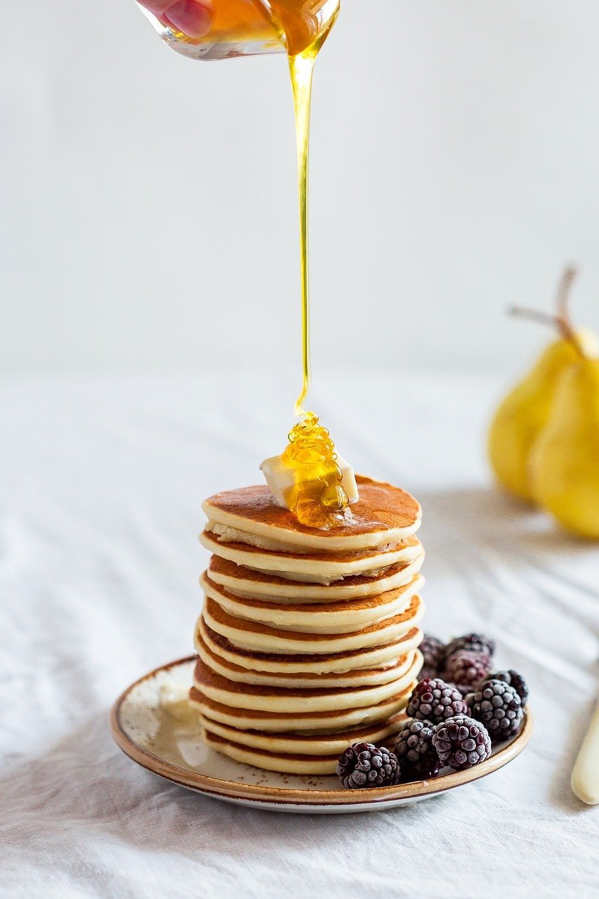 stack of pancakes with honey drizzzled on top