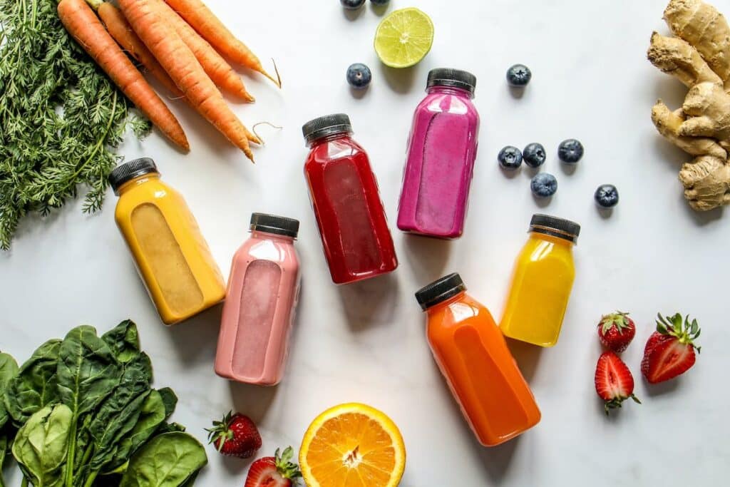 smoothie bottles on a white background with fruits and vegetables