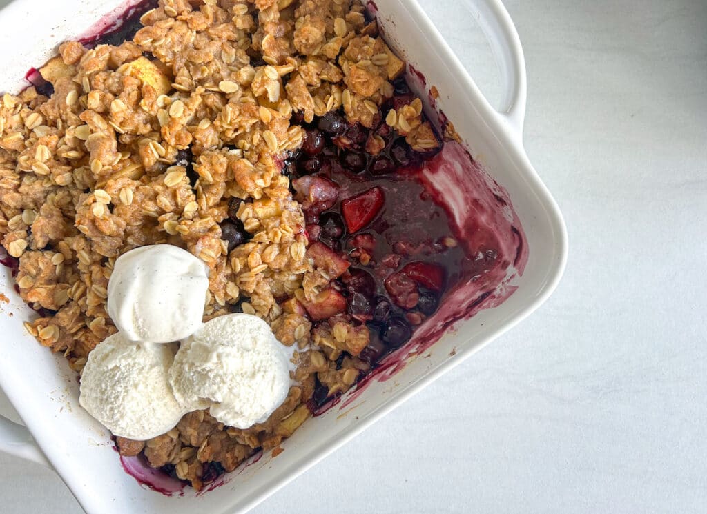 apple & blueberry crumble with ice cream on top