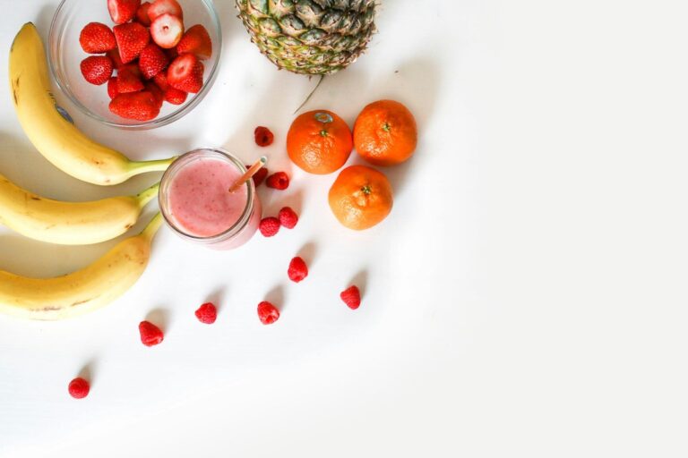 smoothie on a table with bananas and berries