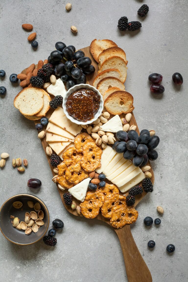 cheese, crackers, and fruit on a snack board